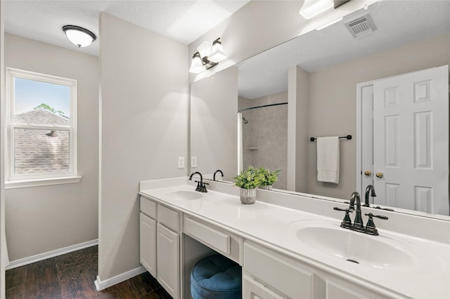 14427 Wickhurst Pl, Cypress, TX 77429 - bathroom featuring double vanity, wood finished floors, and a shower