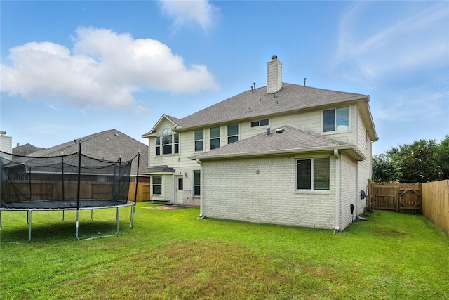 21142 Granite Trail Ln, Richmond, TX 77407 - back of property with a trampoline, a chimney, a fenced backyard, and brick siding