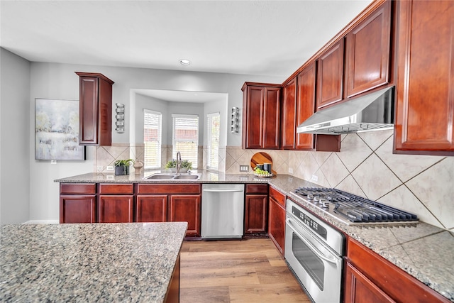 21142 Granite Trail Ln, Richmond, TX 77407 - kitchen featuring appliances with stainless steel finishes, under cabinet range hood, dark brown cabinets, light wood finished floors, and recessed lighting