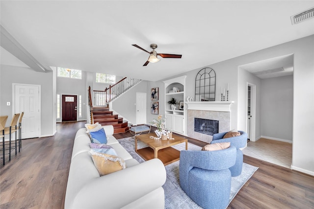 21142 Granite Trail Ln, Richmond, TX 77407 - living area featuring a tile fireplace, stairs, built in features, and wood finished floors