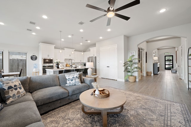 29726 Smoky Ridge Rd, Fulshear, TX 77441 - living room featuring a ceiling fan, light wood finished floors, arched walkways, and recessed lighting