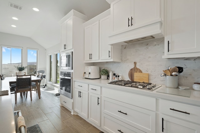 29726 Smoky Ridge Rd, Fulshear, TX 77441 - kitchen with stainless steel appliances, vaulted ceiling, backsplash, light countertops, and white cabinetry