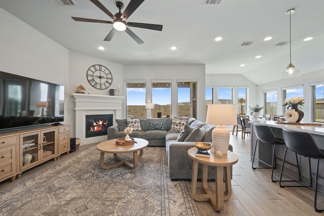 29726 Smoky Ridge Rd, Fulshear, TX 77441 - living area with lofted ceiling, light wood-style flooring, a glass covered fireplace, recessed lighting, and a ceiling fan
