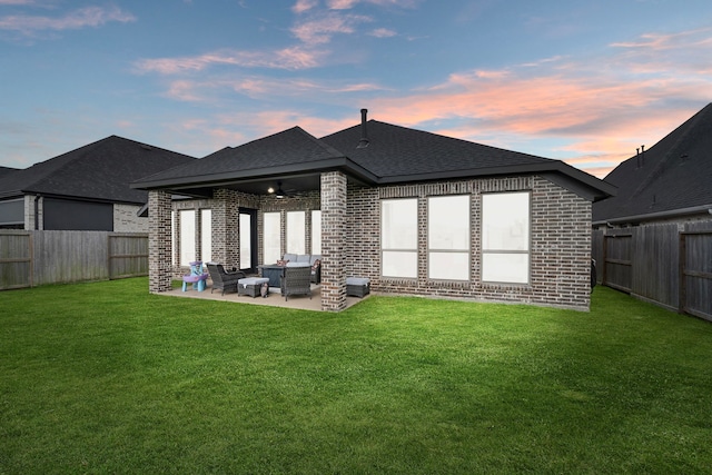 29726 Smoky Ridge Rd, Fulshear, TX 77441 - back of property at dusk featuring brick siding, ceiling fan, a patio, and roof with shingles