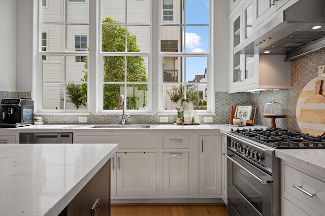 1217 Timbergrove Acres St, Houston, TX 77008 - kitchen featuring appliances with stainless steel finishes, under cabinet range hood, decorative backsplash, and white cabinetry