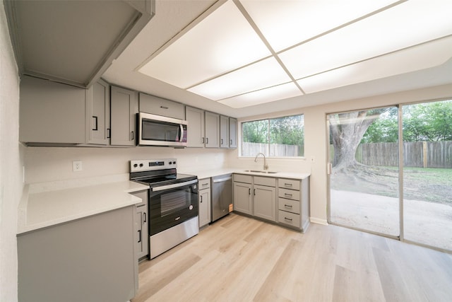 7911 Bova Rd, Houston, TX 77064 - kitchen featuring appliances with stainless steel finishes, gray cabinetry, light wood finished floors, and light countertops