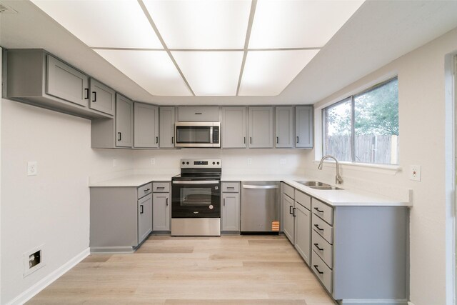7911 Bova Rd, Houston, TX 77064 - kitchen featuring stainless steel appliances, gray cabinetry, light wood-style floors, and light countertops