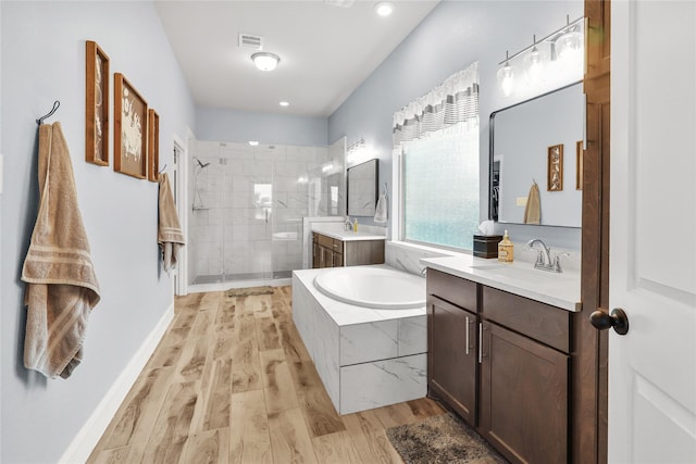 4802 Wagtail Way Ln, League City, TX 77573 - full bathroom featuring two vanities, a shower stall, a bath, wood finished floors, and recessed lighting
