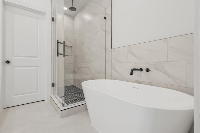 7411 Charlie St, Houston, TX 77088 - full bathroom with a shower stall, a soaking tub, tile walls, and tile patterned flooring