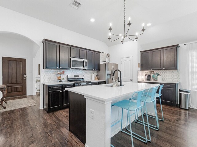 3327 Jane Way, Richmond, TX 77406 - kitchen featuring stainless steel appliances, decorative backsplash, a chandelier, light countertops, and arched walkways