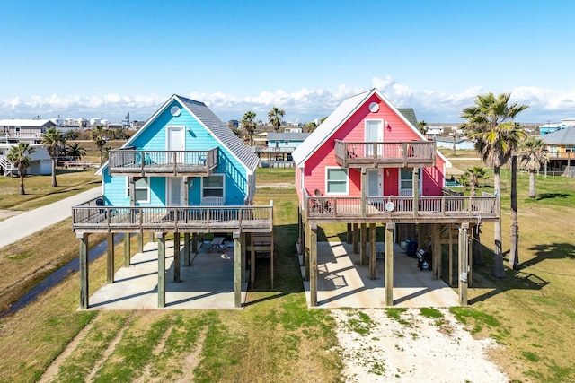 1214 Fort Velasco Dr, Surfside Beach, TX 77541 - back of property with a carport, dirt driveway, a balcony, and a deck