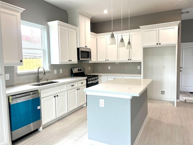 153 Treasure Dr, Houston, TX 77076 - kitchen with stainless steel appliances, white cabinets, a kitchen island, tasteful backsplash, and recessed lighting