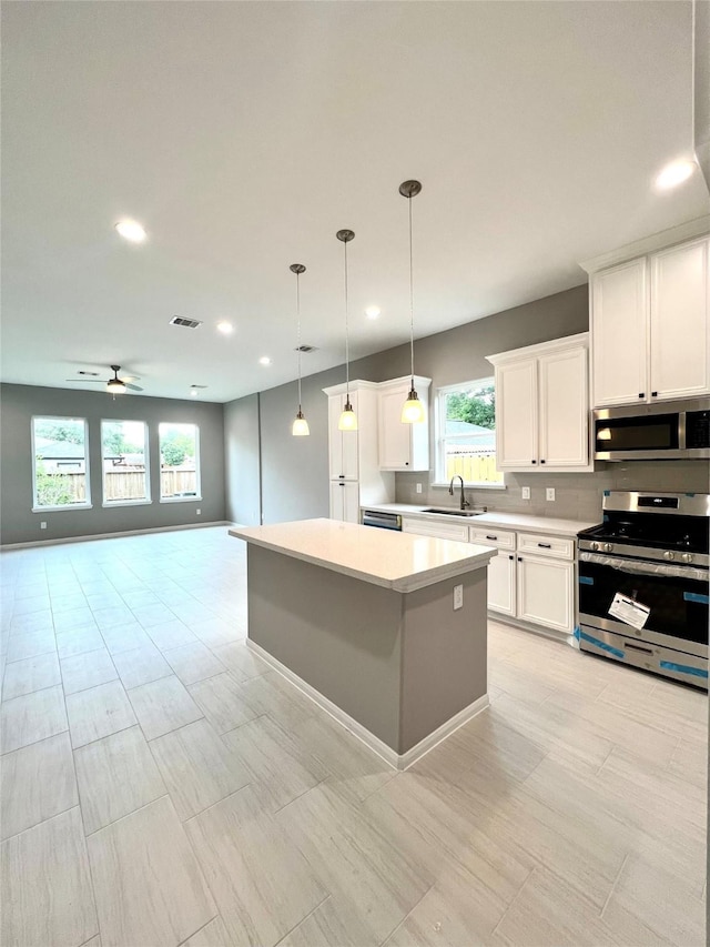 153 Treasure Dr, Houston, TX 77076 - kitchen featuring stainless steel appliances, light countertops, open floor plan, a center island, and recessed lighting