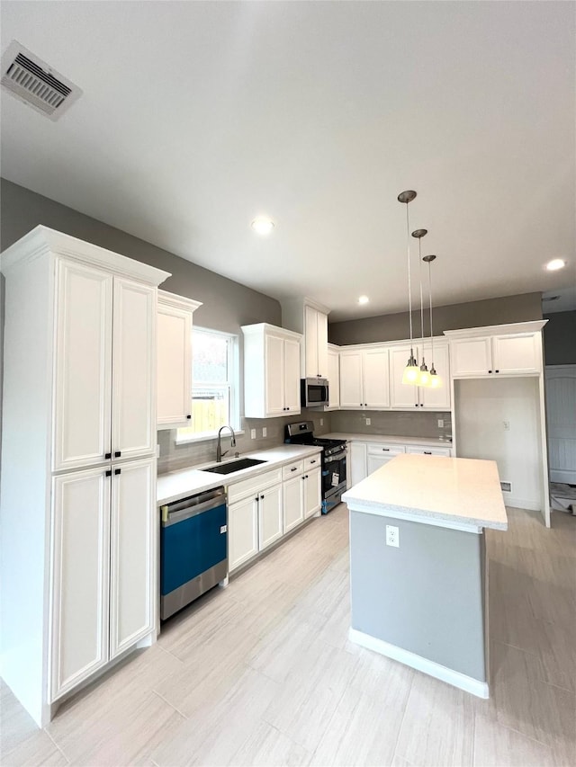 153 Treasure Dr, Houston, TX 77076 - kitchen with appliances with stainless steel finishes, white cabinetry, light countertops, pendant lighting, and recessed lighting