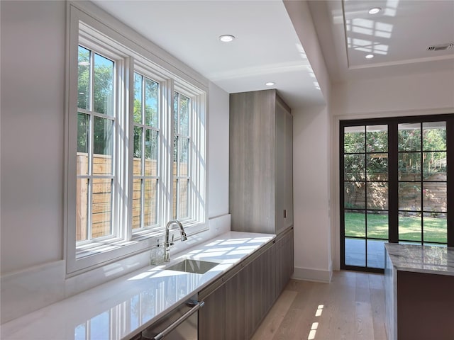 3818 Drake St, Houston, TX 77005 - kitchen featuring modern cabinets, light wood finished floors, stainless steel dishwasher, light stone countertops, and recessed lighting