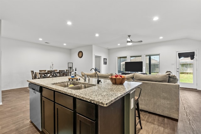 20214 Portbec Dr, New Caney, TX 77357 - kitchen featuring dishwasher, dark brown cabinetry, a center island with sink, recessed lighting, and wood finished floors