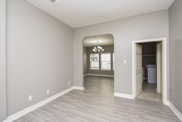 4706 Torrington Ct, Sugar Land, TX 77479 - empty room featuring washer / dryer, arched walkways, a chandelier, and light wood finished floors