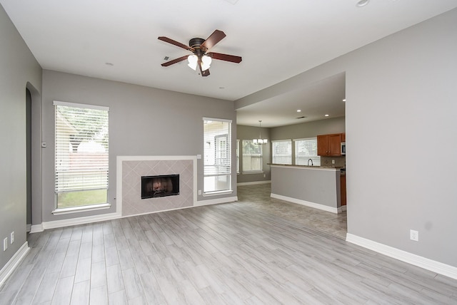 4706 Torrington Ct, Sugar Land, TX 77479 - unfurnished living room featuring a ceiling fan, a tile fireplace, light wood-style floors, and recessed lighting