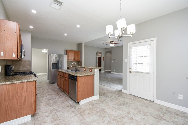 4706 Torrington Ct, Sugar Land, TX 77479 - kitchen featuring stainless steel appliances, a chandelier, a ceiling fan, arched walkways, and decorative backsplash
