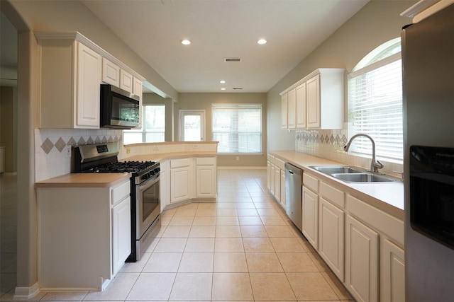 105 N Hollylaurel Cir, The Woodlands, TX 77382 - kitchen featuring appliances with stainless steel finishes, light countertops, backsplash, recessed lighting, and white cabinetry