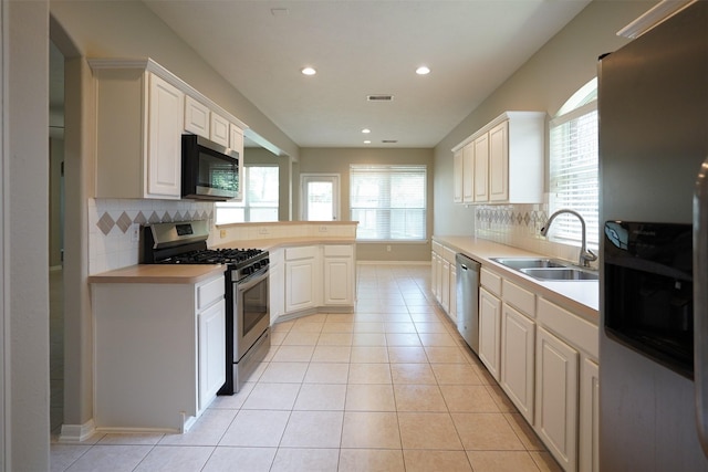 105 N Hollylaurel Cir, The Woodlands, TX 77382 - kitchen featuring stainless steel appliances, light countertops, tasteful backsplash, light tile patterned floors, and recessed lighting