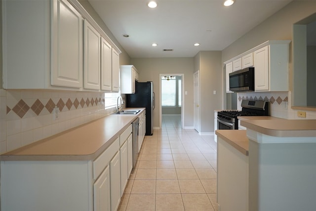 105 N Hollylaurel Cir, The Woodlands, TX 77382 - kitchen featuring appliances with stainless steel finishes, backsplash, white cabinets, recessed lighting, and light tile patterned floors