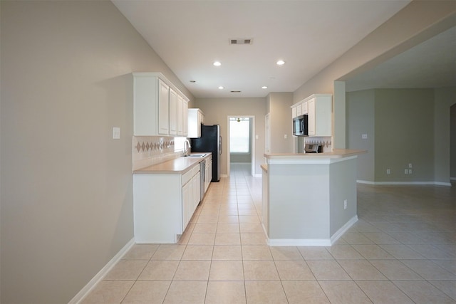 105 N Hollylaurel Cir, The Woodlands, TX 77382 - kitchen with light tile patterned floors, stainless steel microwave, light countertops, white cabinetry, and recessed lighting