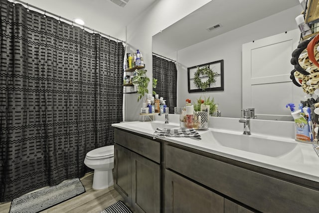 10009 Gray Jay Ct, Conroe, TX 77384 - full bathroom featuring wood finished floors, double vanity, and a shower with shower curtain