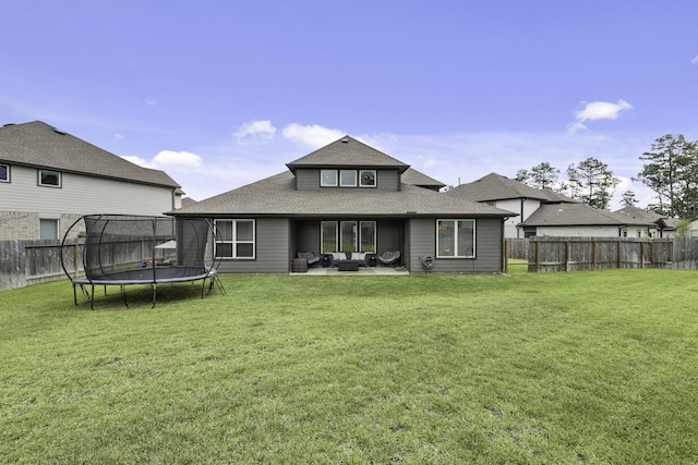 10009 Gray Jay Ct, Conroe, TX 77384 - back of property featuring a trampoline, an outdoor living space, a fenced backyard, and roof with shingles