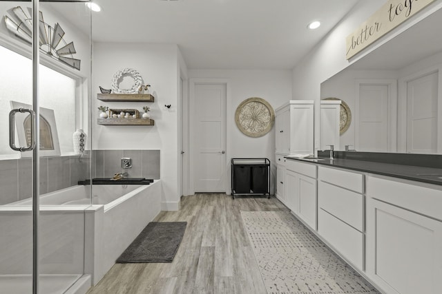 10009 Gray Jay Ct, Conroe, TX 77384 - full bathroom featuring wood finished floors, vanity, a garden tub, and recessed lighting