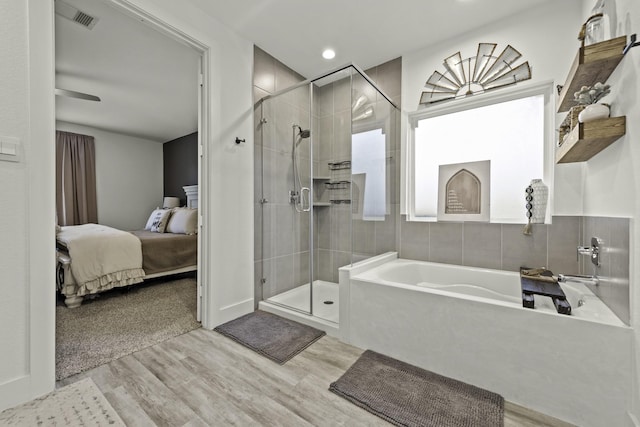 10009 Gray Jay Ct, Conroe, TX 77384 - ensuite bathroom featuring a bath, wood finished floors, and a shower stall