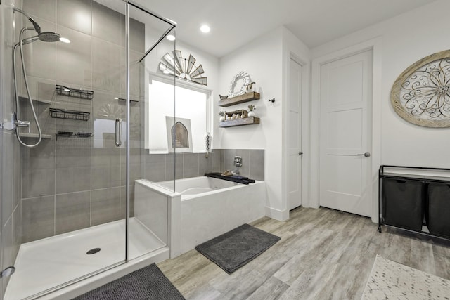 10009 Gray Jay Ct, Conroe, TX 77384 - bathroom with a shower stall, a bath, wood finished floors, and recessed lighting