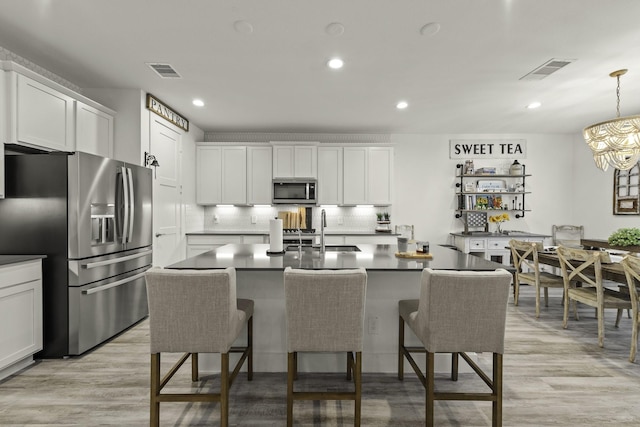 10009 Gray Jay Ct, Conroe, TX 77384 - kitchen with stainless steel appliances, tasteful backsplash, white cabinets, dark countertops, and recessed lighting