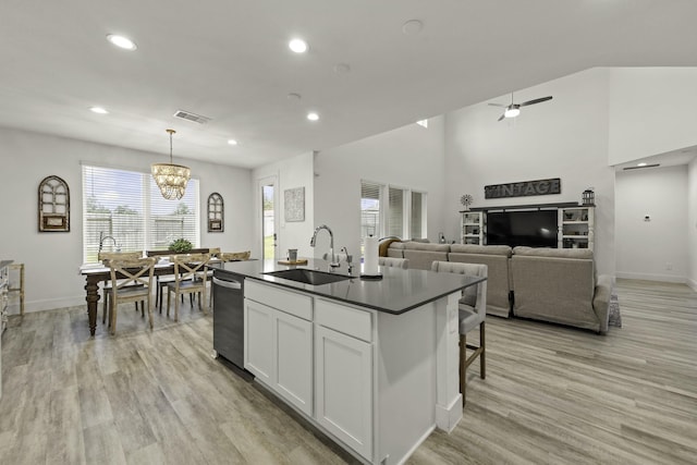 10009 Gray Jay Ct, Conroe, TX 77384 - kitchen with dark countertops, dishwasher, recessed lighting, light wood-type flooring, and a kitchen island with sink