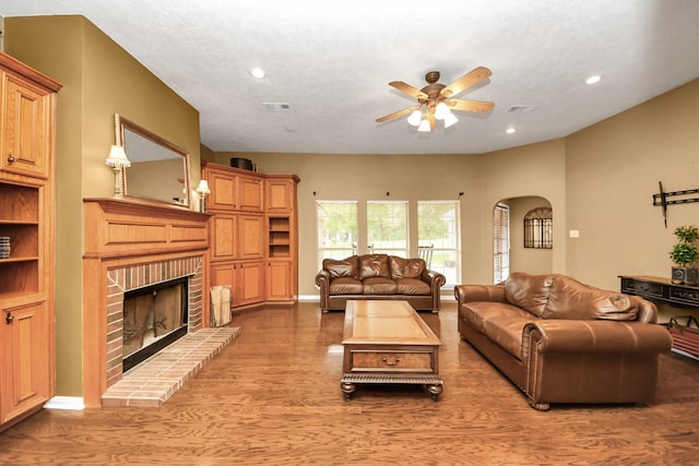 5874 Natchez Trce, Baytown, TX 77523 - living room featuring ceiling fan, arched walkways, a fireplace, recessed lighting, and light wood-style flooring