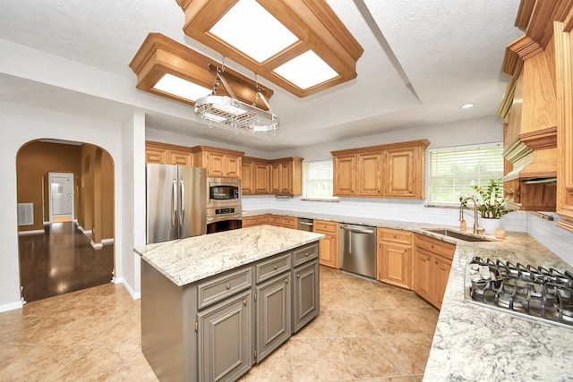 5874 Natchez Trce, Baytown, TX 77523 - kitchen with stainless steel appliances, arched walkways, a center island, tasteful backsplash, and light stone counters