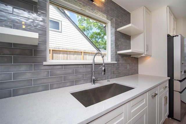 7710 Meadowvale Dr, Houston, TX 77063 - kitchen with stainless steel refrigerator with ice dispenser, open shelves, white cabinetry, and decorative backsplash