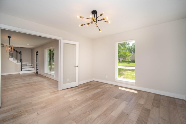7710 Meadowvale Dr, Houston, TX 77063 - spare room with a chandelier, stairway, and light wood-style flooring