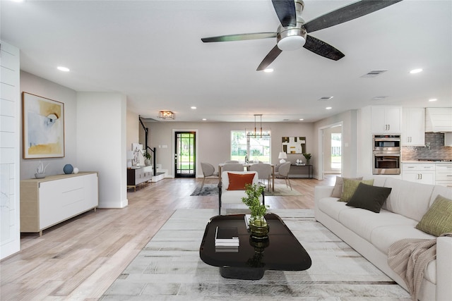 7710 Meadowvale Dr, Houston, TX 77063 - living area featuring light wood-type flooring, ceiling fan, recessed lighting, and a chandelier