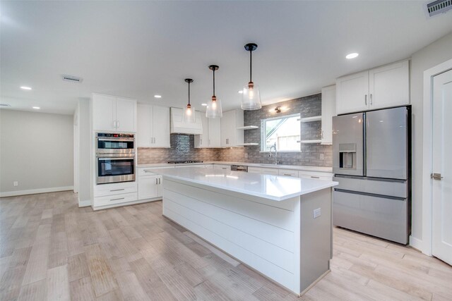 7710 Meadowvale Dr, Houston, TX 77063 - kitchen with stainless steel appliances, backsplash, a center island, light countertops, and recessed lighting