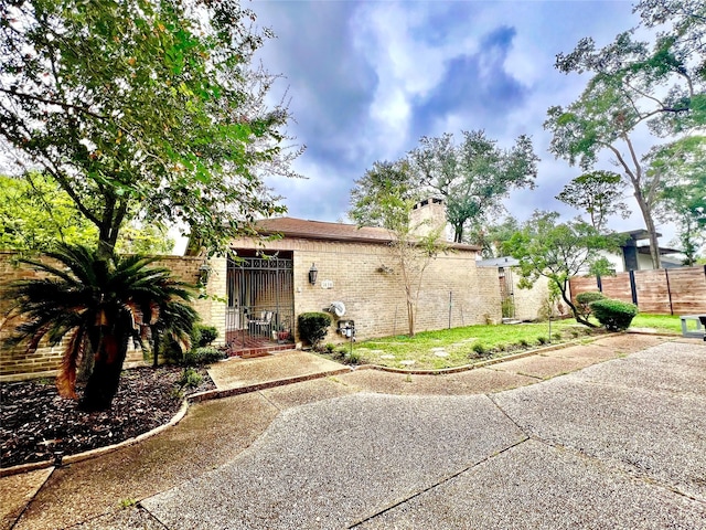 5610 Woodway Dr, Houston, TX 77056 - rear view of property featuring a chimney, brick siding, and a gate