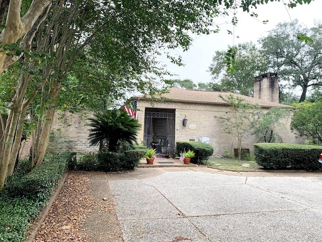 5610 Woodway Dr, Houston, TX 77056 - view of front of property featuring brick siding, a chimney, and a patio area