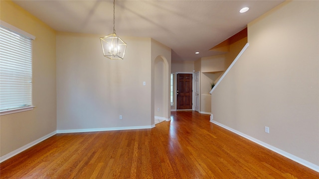 19943 Silver Rock Dr, Katy, TX 77449 - unfurnished dining area with wood finished floors, a chandelier, recessed lighting, plenty of natural light, and arched walkways