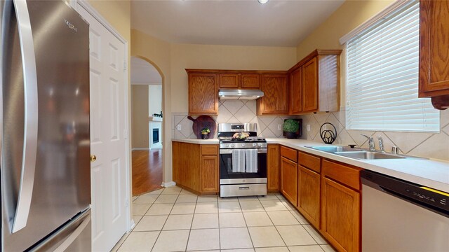 19943 Silver Rock Dr, Katy, TX 77449 - kitchen featuring stainless steel appliances, under cabinet range hood, light tile patterned flooring, and light countertops