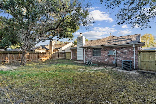 20062 S Pecos Valley Trl, Katy, TX 77449 - back of house featuring brick siding, a fenced backyard, a chimney, and a shingled roof
