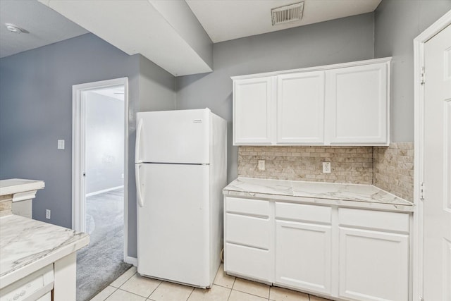 4340 Phlox St A/B, Unit A/B Houston, TX 77051 - kitchen with freestanding refrigerator, white cabinetry, backsplash, and light tile patterned floors