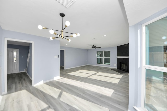 4211 Royal Manor Dr, Pasadena, TX 77505 - unfurnished living room with a chandelier, light wood-style flooring, a fireplace, and a ceiling fan
