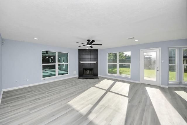 4211 Royal Manor Dr, Pasadena, TX 77505 - unfurnished living room featuring wood finished floors, ceiling fan, a tiled fireplace, and recessed lighting