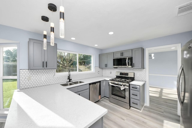 4211 Royal Manor Dr, Pasadena, TX 77505 - kitchen featuring appliances with stainless steel finishes, gray cabinetry, light countertops, light wood-style flooring, and recessed lighting