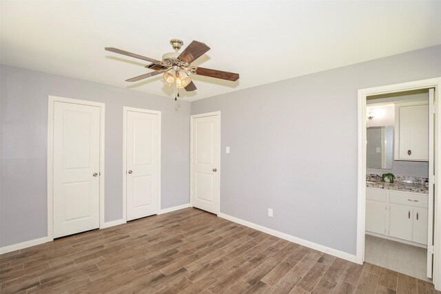 13329 24th St, Santa Fe, TX 77510 - unfurnished bedroom with wood finished floors, ensuite bath, a ceiling fan, and two closets
